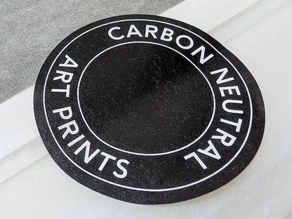 Round 'Carbon Neutral Art Prints' label on black by Botanographia