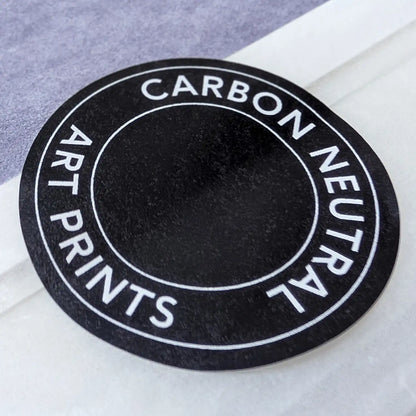 Round 'Carbon Neutral Art Prints' label on black by Botanographia